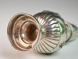 a silver vase that is sitting on a table