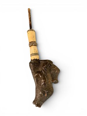 une tête d'éléphant d'où sort un bâton en bois par la trompe