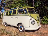 un minibus Volkswagen jaune et blanc garé dans un champ, avec des arbres en arrière-plan