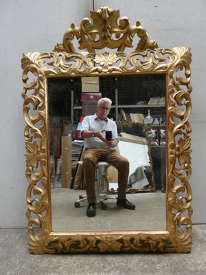 un homme assis devant un miroir