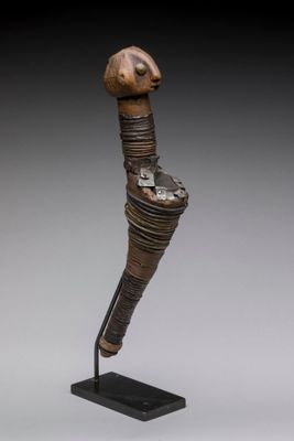 une statue en bronze représentant un oiseau au long cou, posée sur un socle