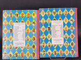 two children ' s books are lined up on a black surface