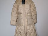 un manteau à capuche posé sur un mannequin contre un mur blanc