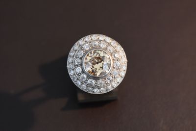 une bague en diamant posée sur une surface noire, avec une ombre
