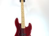 an electric bass guitar on a stand against a white background