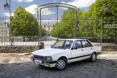 a white car that is parked in front of a gate
