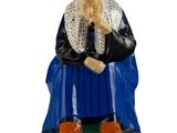 une figurine représentant une femme assise sur un banc