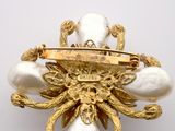 an image of a gold and pearl broochle on a white background