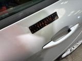 a close up of a car door handle with a sticker on it