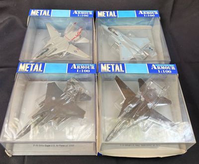 trois boîtes contenant des maquettes d'avions en métal, posées sur une surface noire