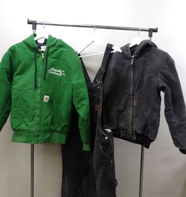 two jackets and pants hanging on a rack in a room