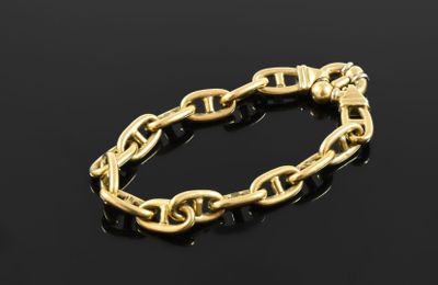 a gold chain bracelet on a black surface