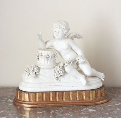 a figurine of a cupid on a marble table