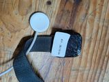 un téléphone portable muni d'une lanière, posé sur une table en bois