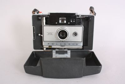 a polaroid camera sitting in a case on a white surface