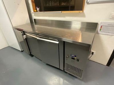 a stainless steel counter with two doors and a glass door