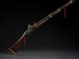 un vieux fusil avec une crosse en bois sur fond noir
