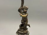 figurine en bronze représentant un garçon tenant une batte de baseball, posée sur un socle