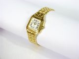 une photo en gros plan d'une montre-bracelet en or posée sur une serviette