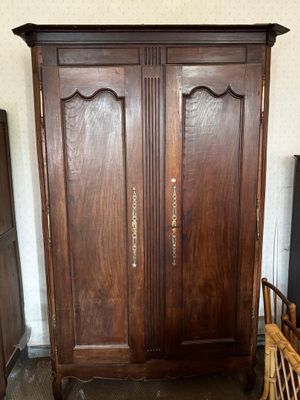 une armoire en bois dans une pièce, avec une chaise à côté