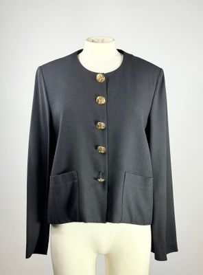 une veste noire à boutons dorés posée sur le torse d'un mannequin