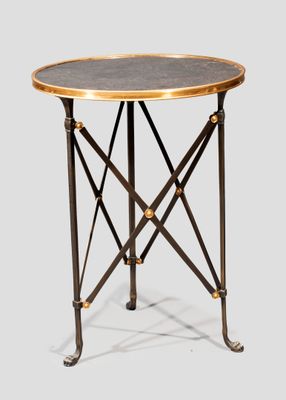 une image représentant une table ronde avec un piètement en métal et un plateau noir