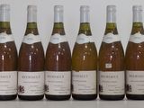 six bottles of wine are lined up in a row on a table