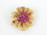 purple and gold flower brooch with pearls on a white background