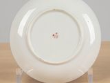 a white plate with a red flower on it