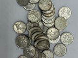 une pile de pièces d'argent posée sur une surface blanche