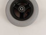 a close up of a black wheel on a white surface