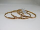 trois bracelets rigides en or sur fond blanc, avec une étiquette de prix