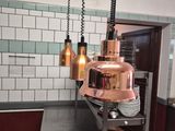 an image of a restaurant kitchen with a copper colored light fixture
