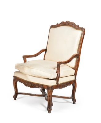 an old chair with a white cushion and a wooden frame