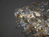 a pile of gold and silver pins on a table
