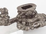 un bougeoir en argent posé sur un socle en verre transparent