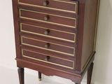 a small chest of drawers on a stand in a room