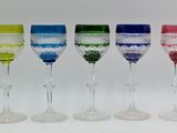 four different colored wine glasses are lined up in a row