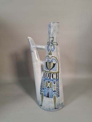 un vase blanc orné d'un motif bleu et jaune