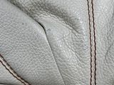 the inside of a white purse with red stitching on it