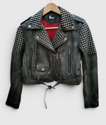 une veste en cuir noir avec des manches cloutées et une chemise rouge