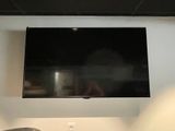 une télévision à écran plat fixée au mur au-dessus d'un lavabo