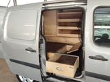 a small white van with open doors and drawers inside of it