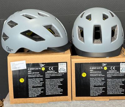 trois casques de vélo posés sur une boîte en carton, elle-même posée sur une table