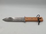 a knife with a wooden handle on a white surface