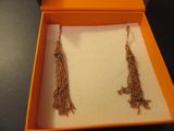 une paire de boucles d'oreilles dans une boîte posée sur une table