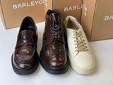 three pairs of brown and white shoes sitting on top of a table