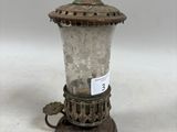 Une lampe à l'ancienne est posée sur une table, avec une étiquette dessus.