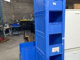 une pile de caisses bleues dans un entrepôt équipé d'un réfrigérateur
