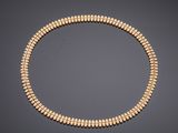 a gold beaded necklace on a black background